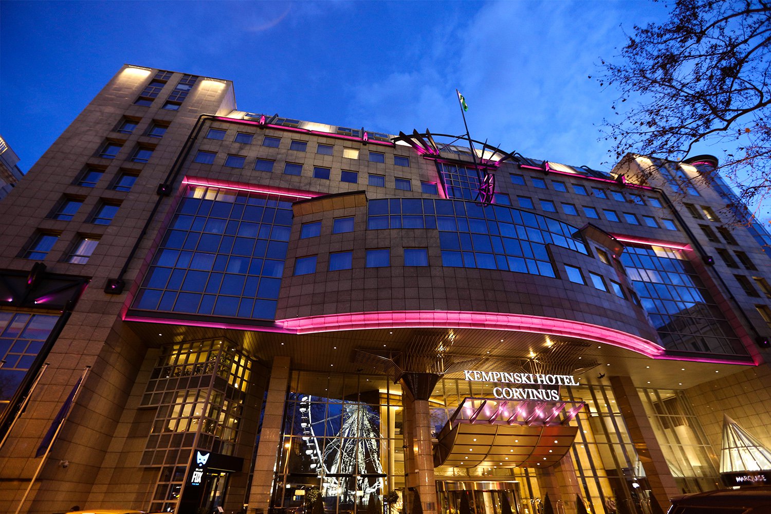 Kempinski Hotel Corvinus entrance at night with pink facade lighting